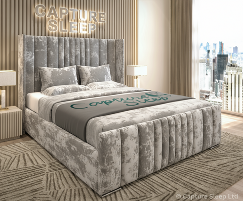 An elegant gray wingback bed frame with a plush velvet fabric, displayed in a stylish room setting.